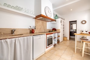 Una cocina equipada con lavavajillas, horno y un reloj en la pared.