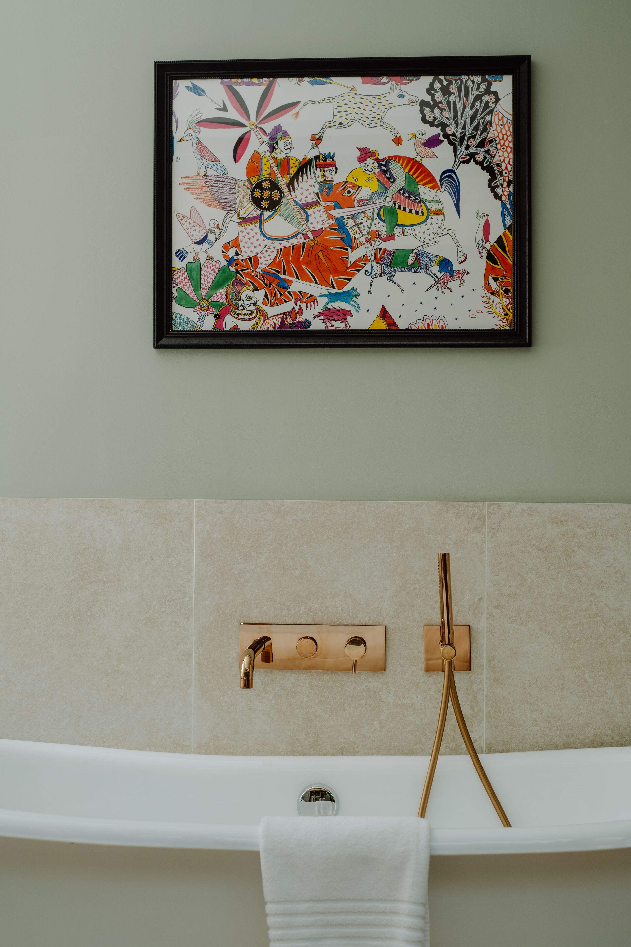 A bathroom with a framed artwork, a towel rack, and a wooden towel holder.