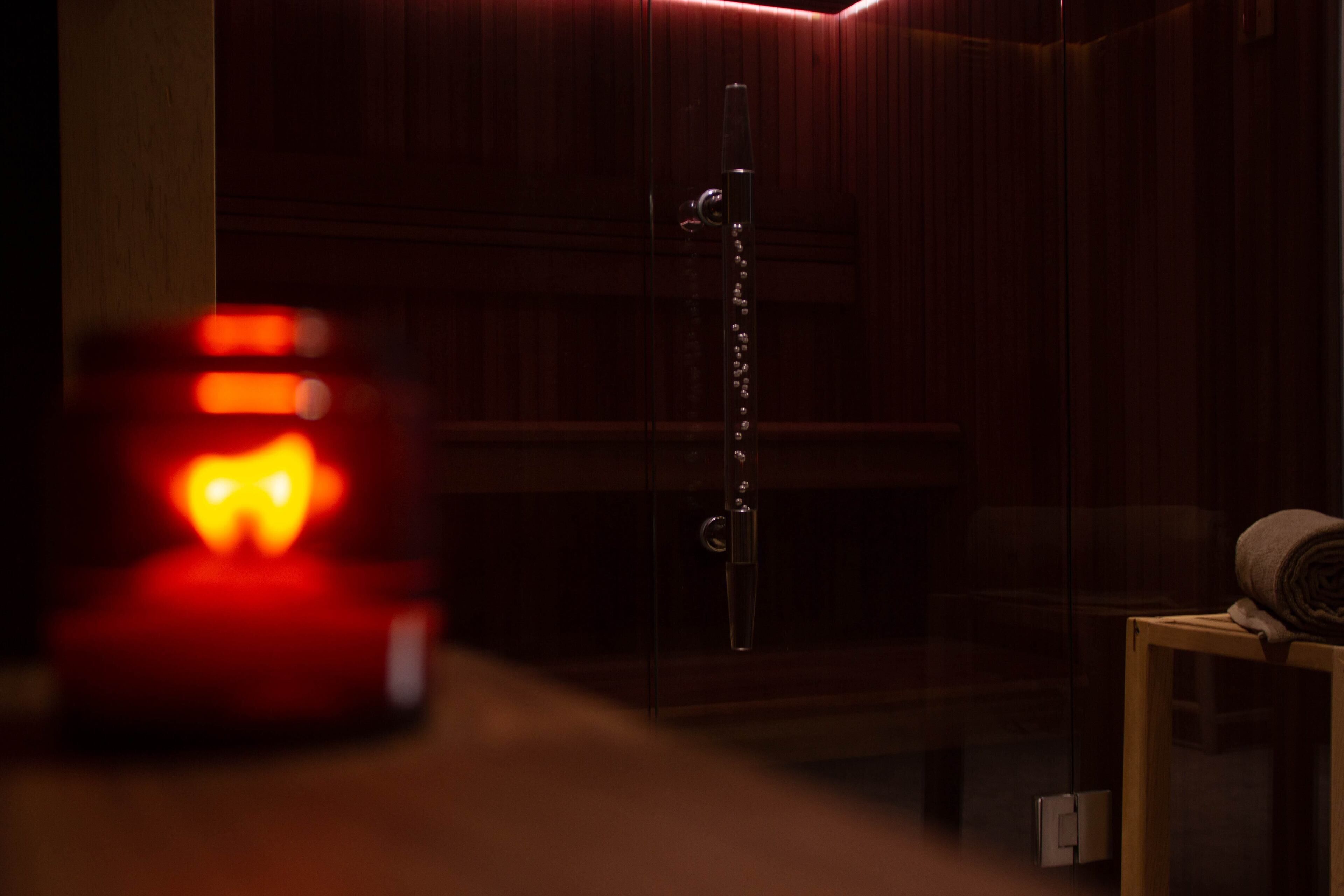 A dimly lit room with a wooden door, a metal chain, and a small table with a rolled-up item.