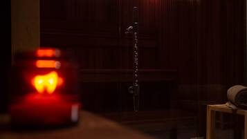 A dimly lit room with a wooden door, a metal chain, and a small table with a rolled-up item.
