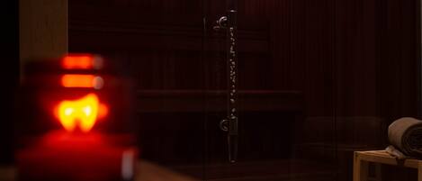 A dimly lit room with a wooden door, a metal chain, and a small table with a rolled-up item.