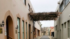 Une rue bordée de bâtiments des deux côtés, caractérisée par des portes et des fenêtres en arc de cercle.