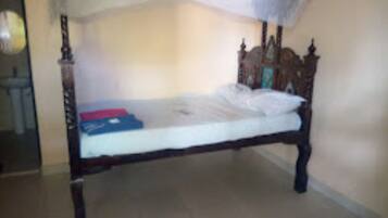A single bed with a wooden frame and white bedding.