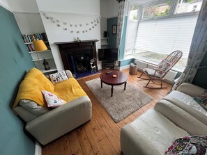 A living room with a fireplace, a sofa, a coffee table, and a rocking chair.