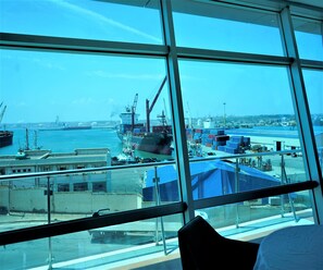 A view from a window of a building overlooking a port with ships and containers. - Plaza Arzew (Arzew)