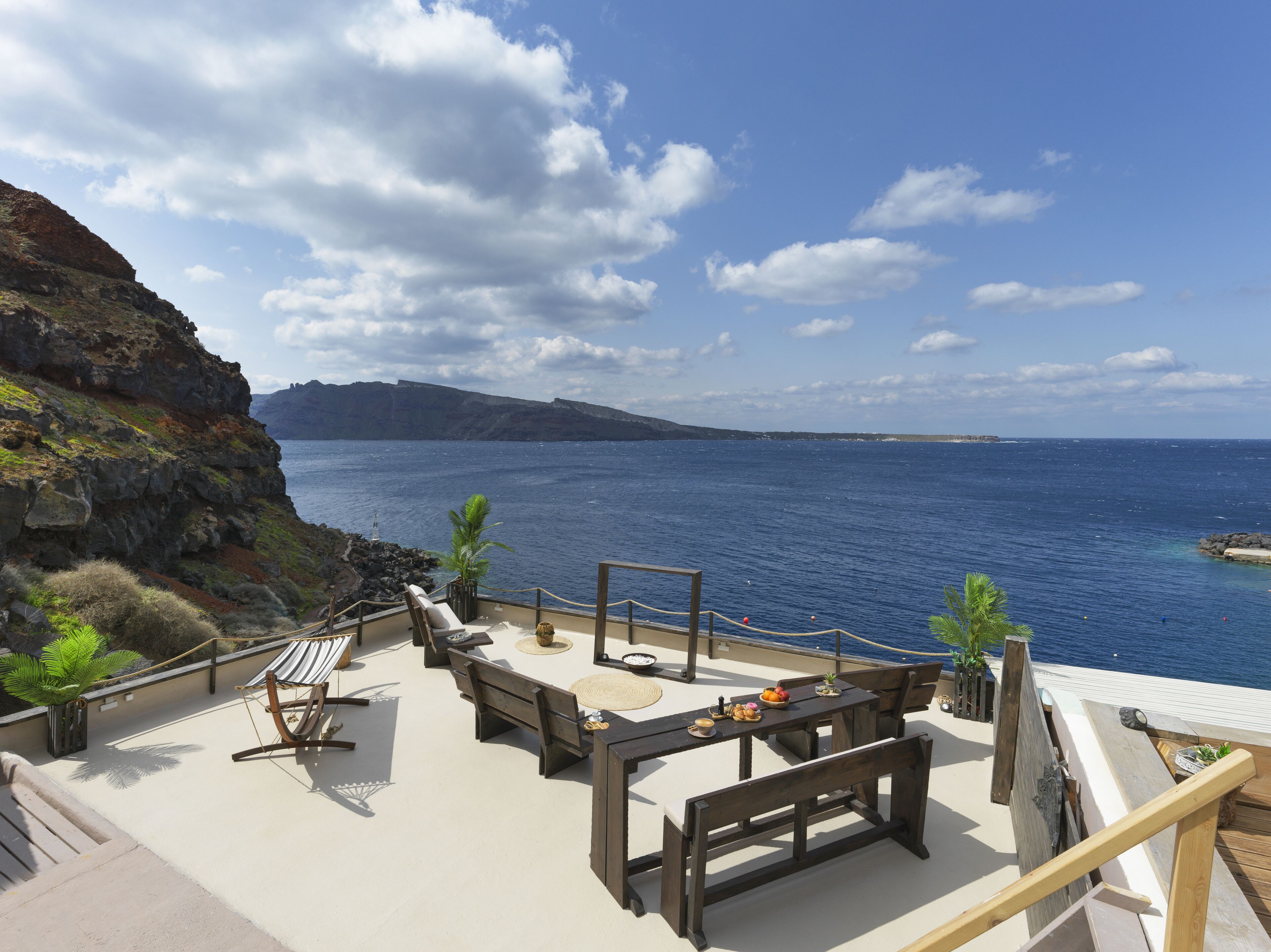 A deck with seating and a view of the ocean.