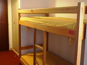 A bunk bed with a wooden frame and a mattress.