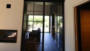Un interior moderno con un portón de vidrio corredizo que da a un espacio exterior.