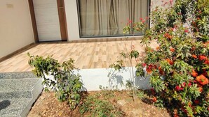 Ein modernes Gebäude mit einer großen Schiebeglastür, einer kleinen Gartenanlage mit verschiedenen Pflanzen und der Nummer 410 an der Wand.