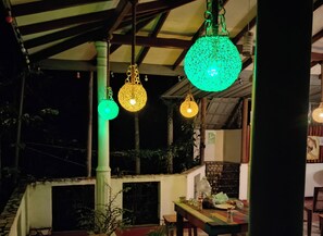 A night scene in a balcony area with hanging lights. - Toropi homestay (Pilimathalawa)