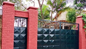 Una entrada protegida por un muro de ladrillo y una reja de metal negro.