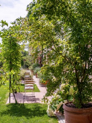 A garden pathway with potted plants and a bench.