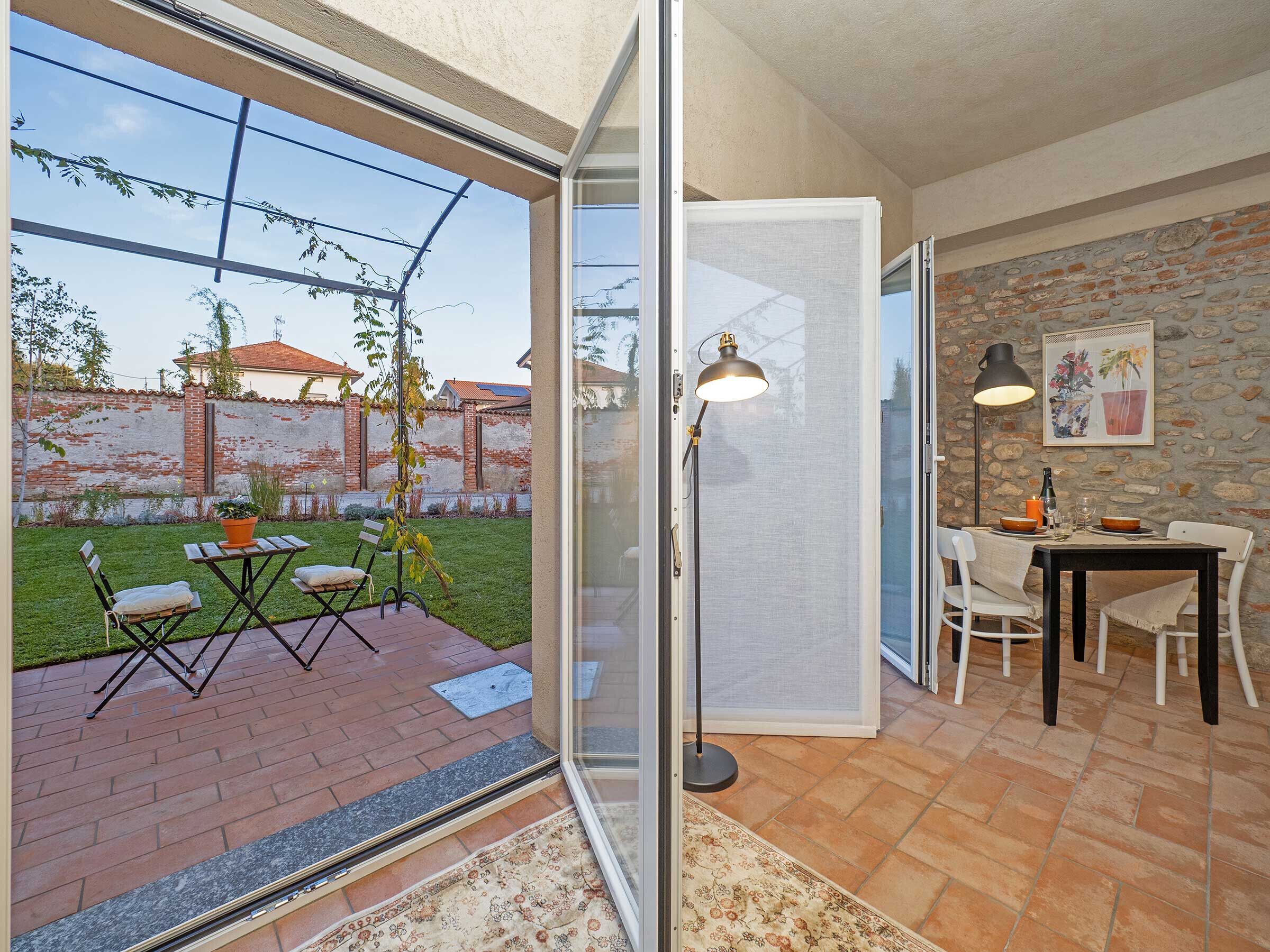 the apartment opens on the garden furnished with table and chairs