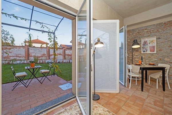 the apartment opens on the garden furnished with table and chairs