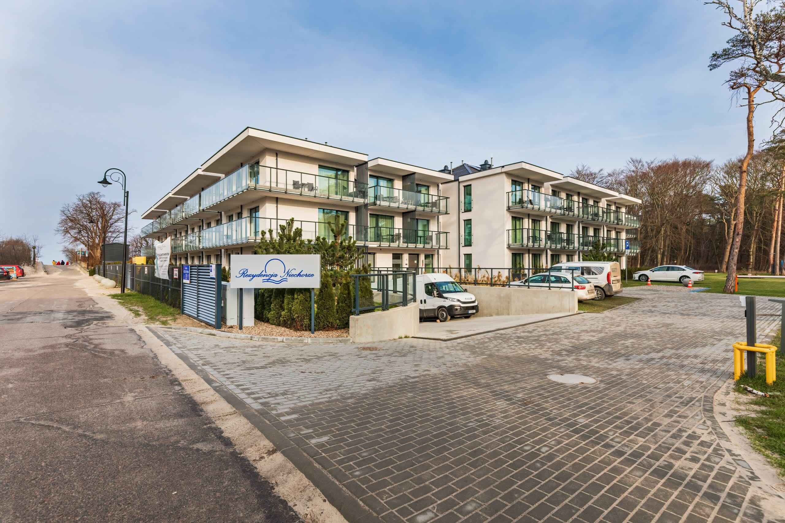 Un bâtiment moderne doté de nombreux balcons et d’une enseigne indiquant « Recyclage Nachor ».