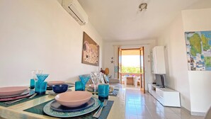 A dining area with a table set for four, a map on the wall, and a view to the outside.
