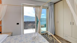 Une chambre à coucher comprenant un lit, une armoire et un balcon avec vue sur le paysage.