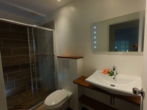 Apartamento conforto, suíte, vista para o jardim (Lagon) | Banheiro | Chuveiro, chuveiro com efeito de chuva, secador de cabelo 
