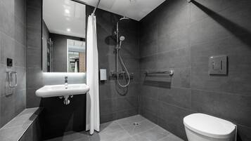 A modern bathroom with a shower, toilet, and sink.