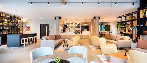 Ein modernes Interieur mit Barbereich, Sitzgelegenheiten und einer Küche.