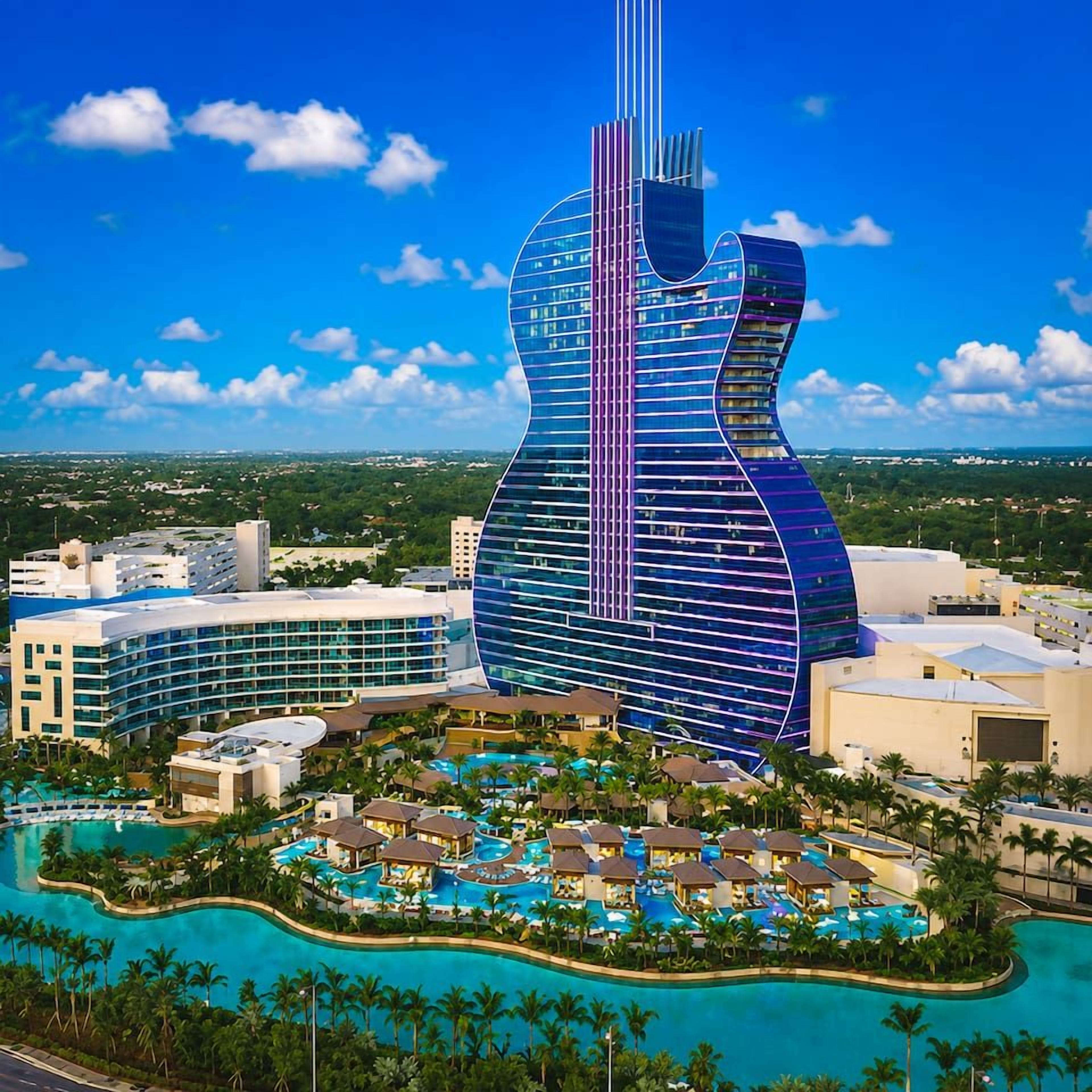 A resort with a guitar-shaped building, multiple swimming pools, and a tropical setting.