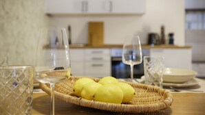 Et køkken med en fletkurv med citroner, et vinglas og et glas på et træbord.