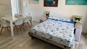 A bedroom with a bed, a desk, chairs, and a dining table. - R House 2 independent semi-detached house (Budoni)
