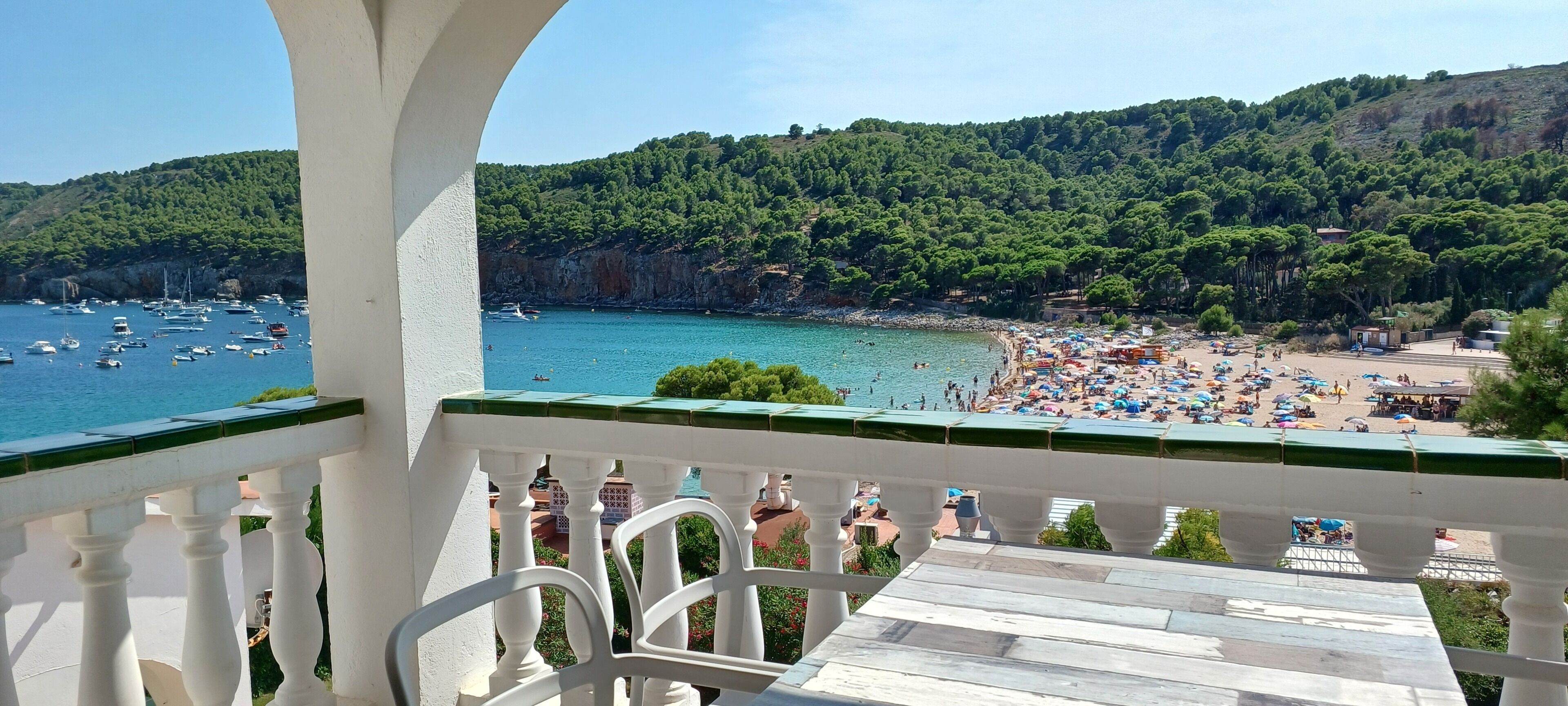 A balcony with a view of a beach and boats.