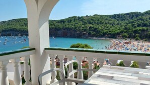 A balcony with a view of a beach and boats.