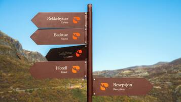 A directional sign with arrows pointing to various accommodations including cabins, apartments, a hotel, and a reception area.