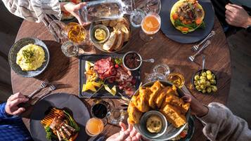 Una mesa redonda para comer con diferentes platos, bebidas y cubiertos.