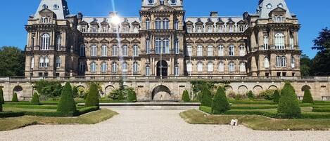 A large, historic building with symmetrical architecture, featuring multiple windows and a central entrance.