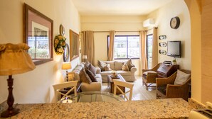 A living room with a sofa, chairs, a TV, and a window with curtains. - Skol 130 - 1-Bedroom Apartment with Sea Views in Marbella Centre (Marbella)