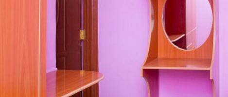 A room with wooden furniture, a purple wall, and a door.