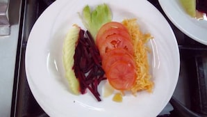 A plate with sliced tomatoes, lettuce, and shredded cheese. - Leopard View Hotel (Nakuru)