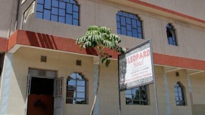 A multi-story building with a beige facade, red accents, and multiple windows. - Leopard View Hotel (Nakuru)