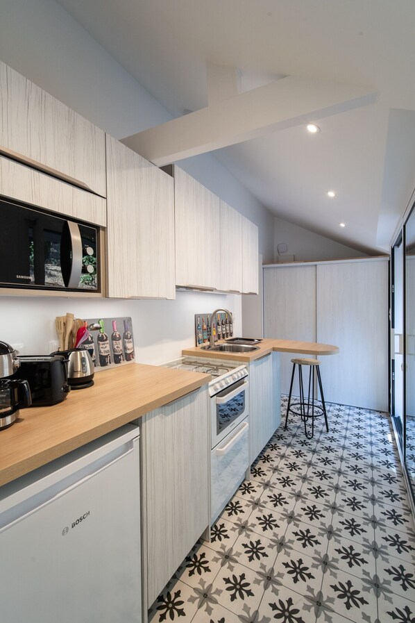 A modern kitchen with white cabinetry, a stainless steel sink, and a Bosch dishwasher. - Le Cottage du Cerf-Gîte-Ensuite with Shower (Francueil)