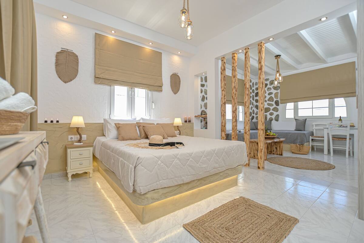 Quarto espaçoso com cama grande, mesas de cabeceira, escrivaninha e vista para o exterior.