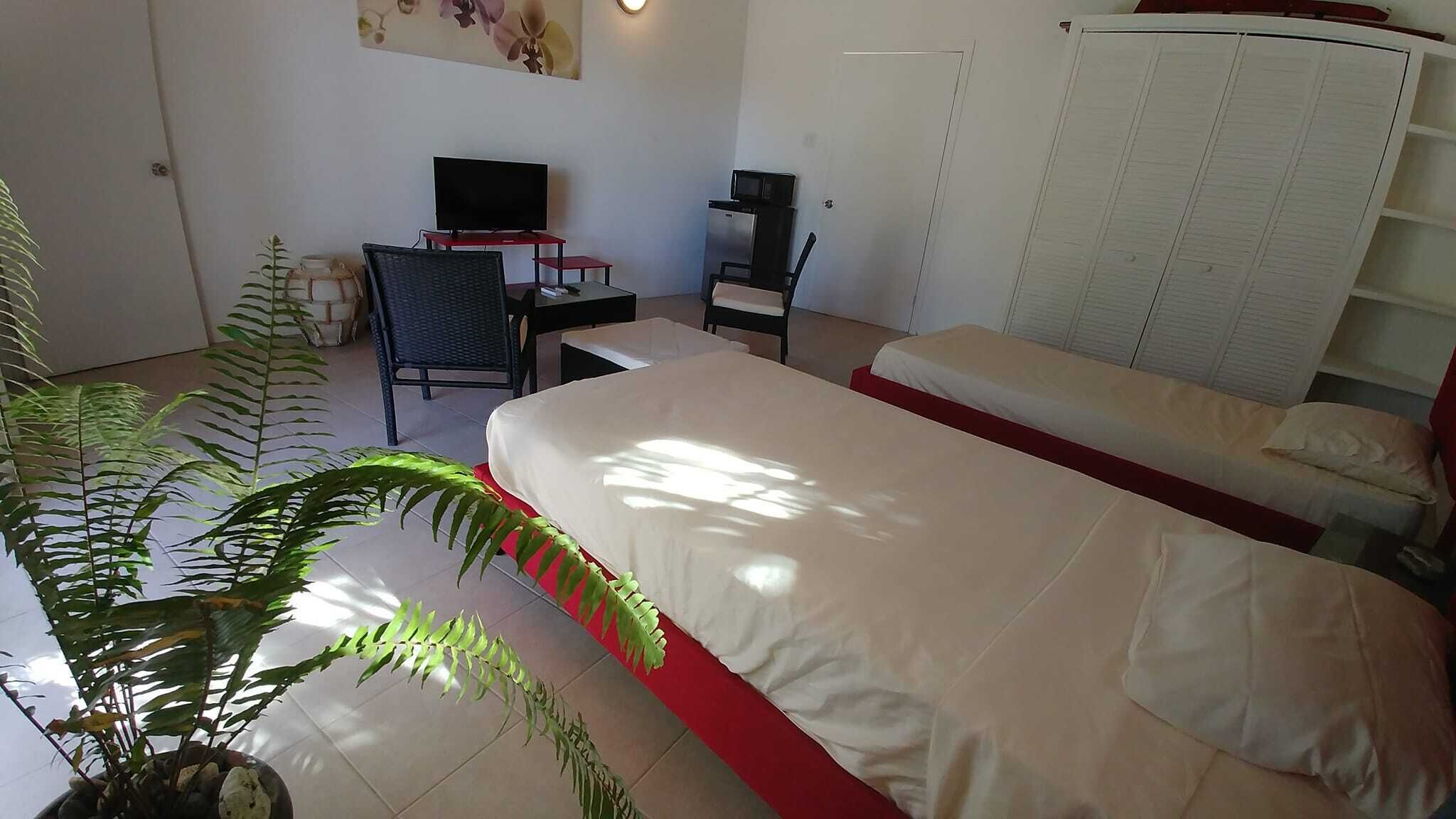 Ein Hotelzimmer mit einem Bett, einem Schreibtisch mit Stuhl, einem Fernseher und einem Kleiderschrank.