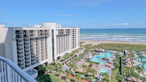 Een hotel met meerdere verdiepingen, een zwembad en uitzicht op het strand.