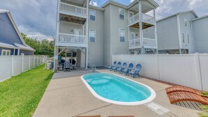 A residential building with a swimming pool, outdoor seating, and a fenced yard. - 4 Bedroom, 3 1/2 Bath Dog-Friendly Beach Home with Private Pool (Garden City Beach)