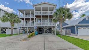A two-story building with a covered front porch and a garage. - 4 Bedroom, 3 1/2 Bath Dog-Friendly Beach Home with Private Pool (Garden City Beach)