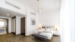 Una camera da letto moderna con un letto grande, comodini, una panca e un lampadario dal design originale.