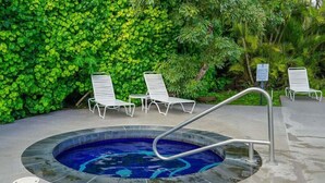 A hot tub surrounded by white lounge chairs, with a lush green wall in the background. - Plantation Hale K10 | 1BR Condo w/ AC, Resort pool,  Private Lanai (Kapaa)