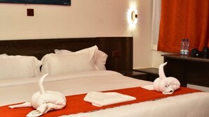 A hotel room with a large bed, a wooden headboard, and a red rug. - Old Station Lounge Naivasha (Naivasha)