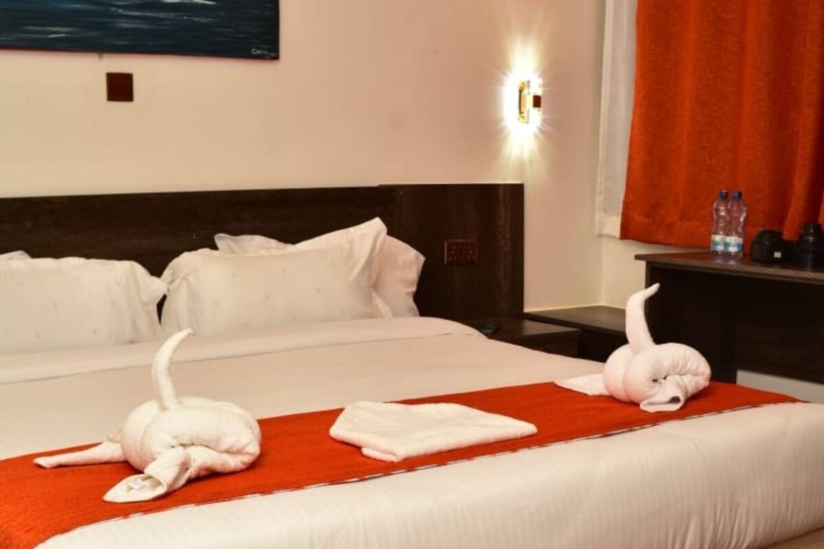 Ein Hotelzimmer mit einem großen Bett, einem Holzkopfteil und einem roten Teppich.