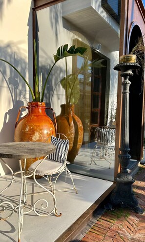 A patio with a table and chairs, large vases, and a mirror reflecting the scene. - To Be Social House - Adults Only  (Fethiye)