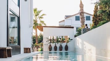 Una piscina al aire libre de temporada, sombrillas