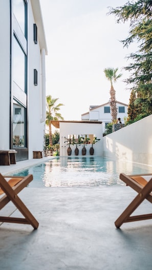 季节性开放的室外游泳池,池畔遮阳伞,日光浴躺椅