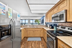 A modern kitchen with a stainless steel refrigerator, a microwave, and an oven.